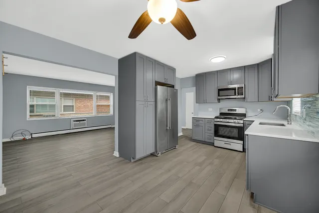 a kitchen with stainless steel appliances granite countertop a stove a sink and a refrigerator