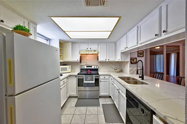 a kitchen with stainless steel appliances granite countertop a sink and a stove