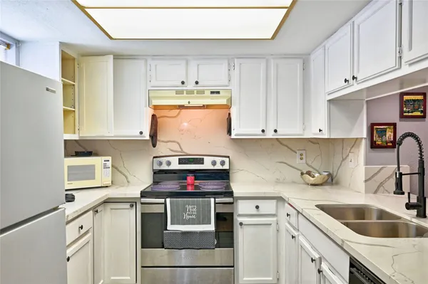 a kitchen with stainless steel appliances a sink a stove and a window
