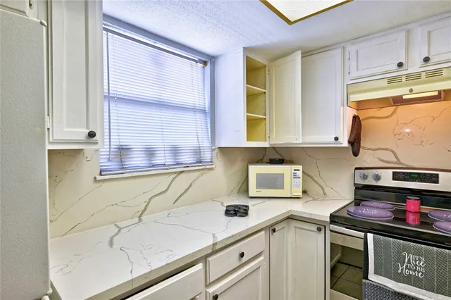 a kitchen with stainless steel appliances granite countertop a sink and cabinets