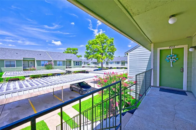 a view of swimming pool with lawn chairs and plants