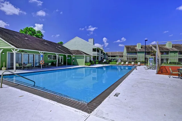 a backyard of a building with plants and bench