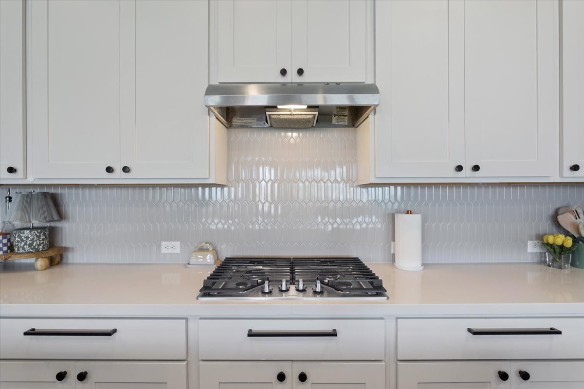 424 Millard Street Georgetown, TX 78628 - Photo 14 of 37 Culinary adventures await in this pristine kitchen, equipped with a gas range and sleek white cabinetry.