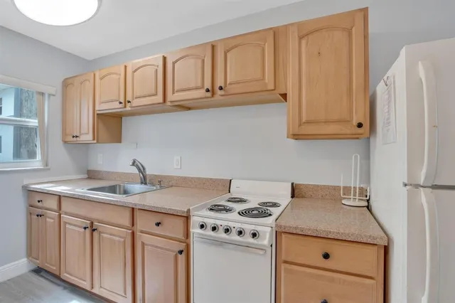 a kitchen with granite countertop a sink stove and cabinets