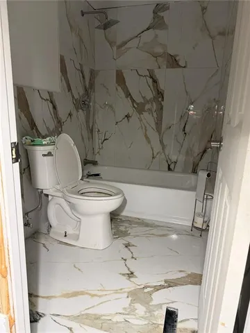 a bathroom with a toilet and a shower