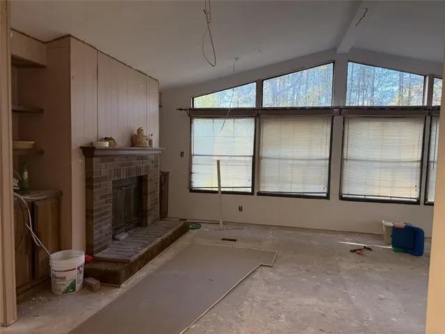 a view of an empty room with a fireplace and a window