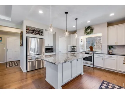 a large kitchen with cabinets wooden floor and stainless steel appliances