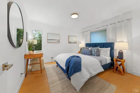 a bedroom with a bed a mirror and a window