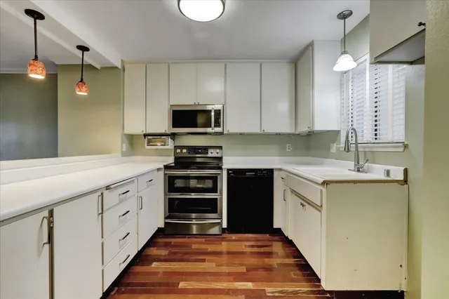a kitchen with cabinets window and stainless steel appliances