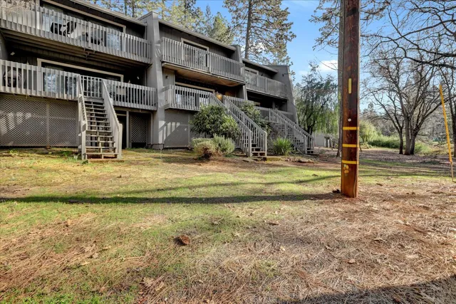 a view of a house with backyard and a tree
