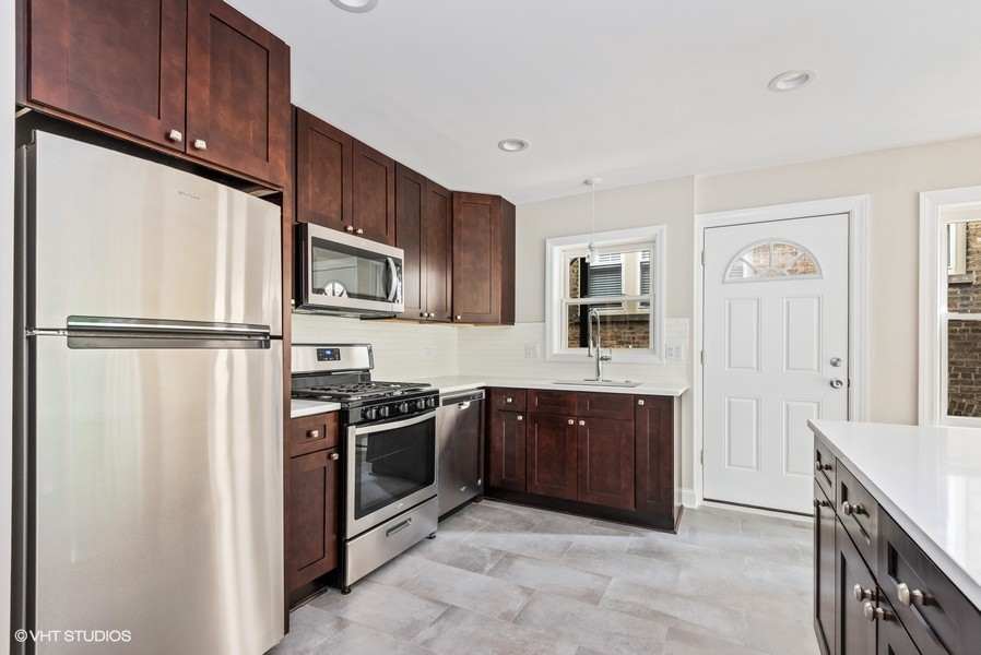 1619 Monroe Street, Unit 1 Evanston, IL 60202 - Photo 5 of 10 a kitchen with stainless steel appliances granite countertop a refrigerator a stove a sink and a microwave