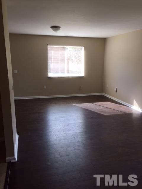 2604 Sanderford Road Raleigh, NC 27610 - Photo 21 of 22 a view of an empty room with wooden floor and a window
