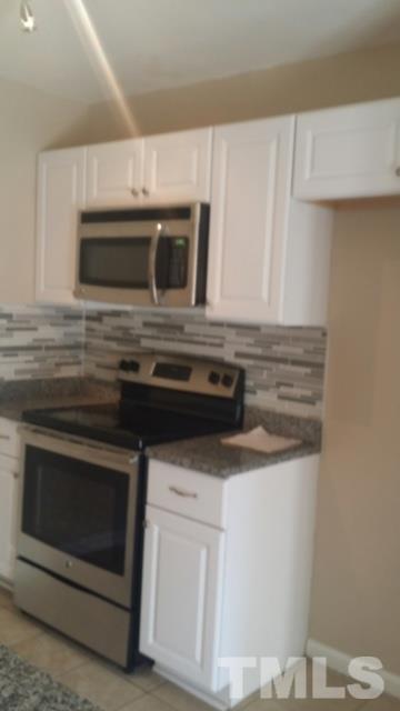 2604 Sanderford Road Raleigh, NC 27610 - Photo 9 of 22 a kitchen with white cabinets and stainless steel appliances