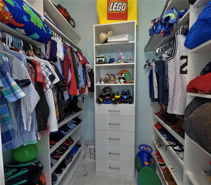 10112 Judy Road Dover, FL 33527 - Photo 23 of 49 a view of walk in closet with clothes and shoes