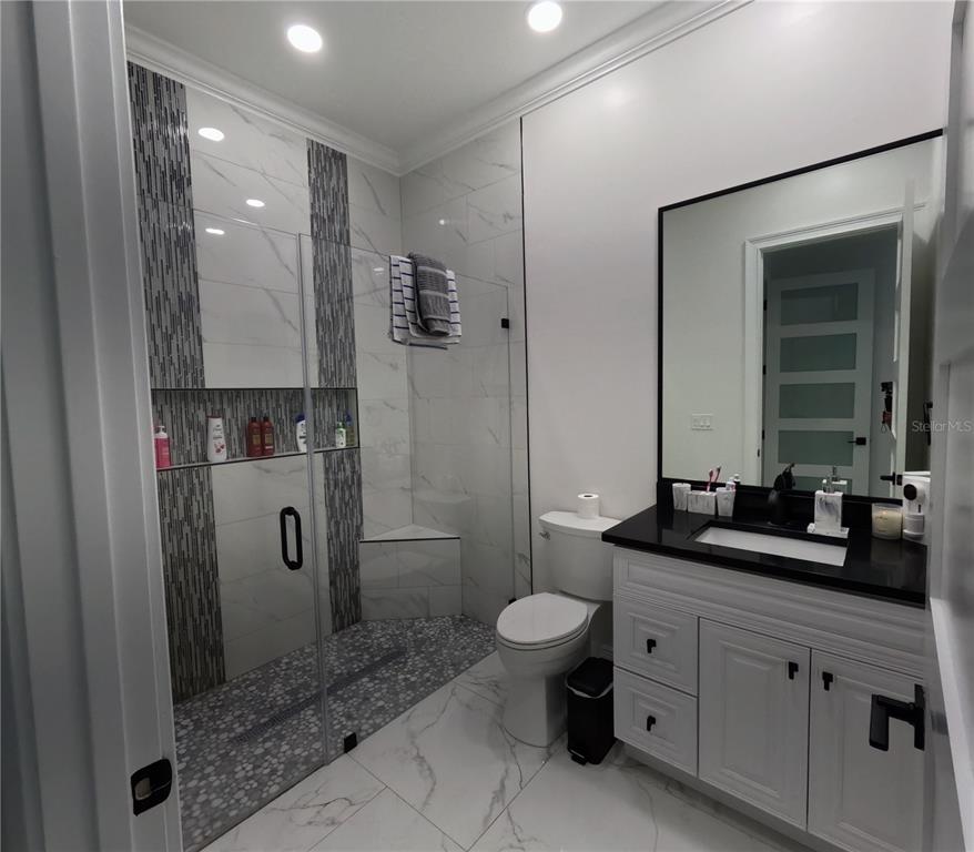 10112 Judy Road Dover, FL 33527 - Photo 26 of 50 a bathroom with a double vanity sink toilet mirror and shower