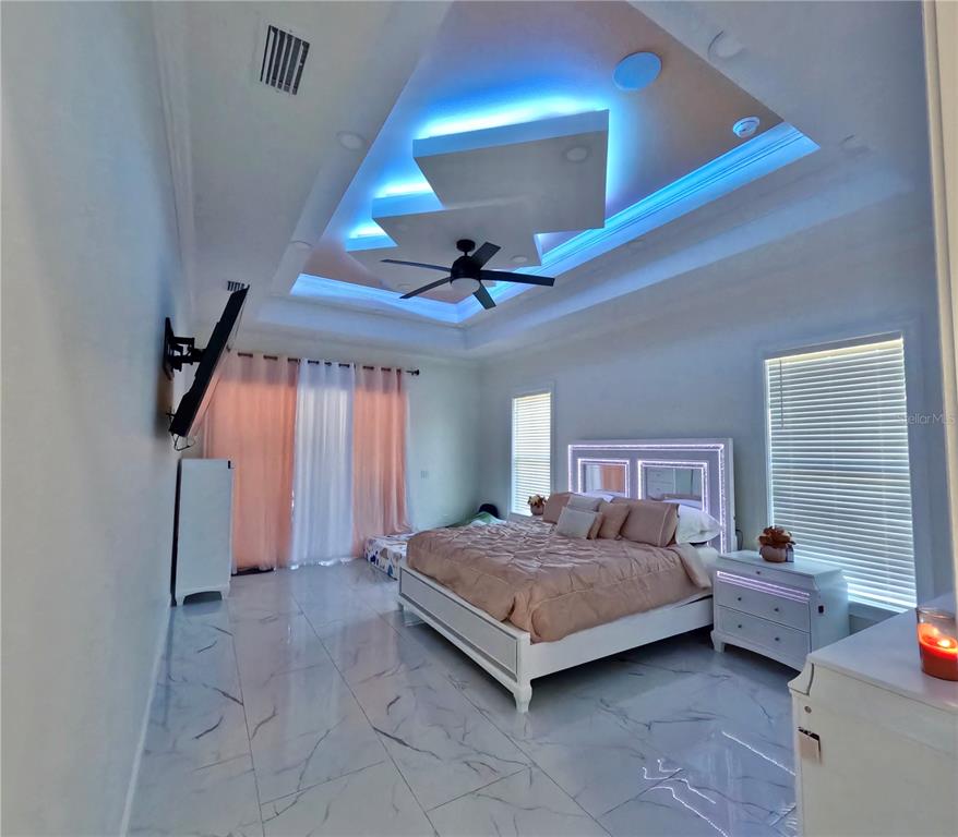 10112 Judy Road Dover, FL 33527 - Photo 27 of 49 a spacious bedroom with a bed and a chandelier