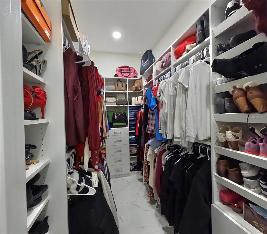 10112 Judy Road Dover, FL 33527 - Photo 32 of 49 a view of walk in closet with clothes and shoes