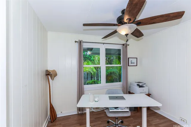 a view of a workspace with furniture and a window