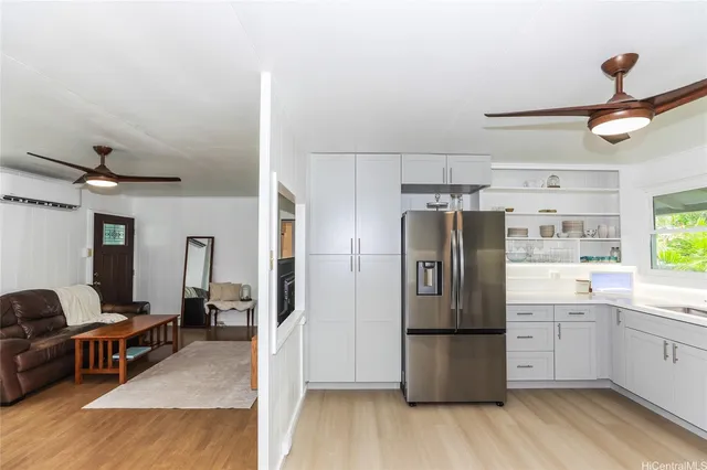 a kitchen with stainless steel appliances granite countertop a refrigerator a sink dishwasher a stove and white countertops with wooden floor