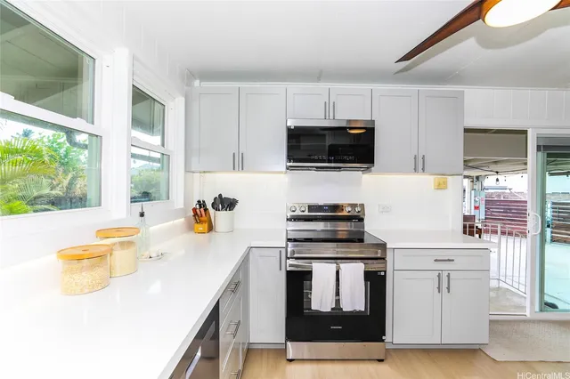 a kitchen with stainless steel appliances a stove a sink a microwave and cabinets