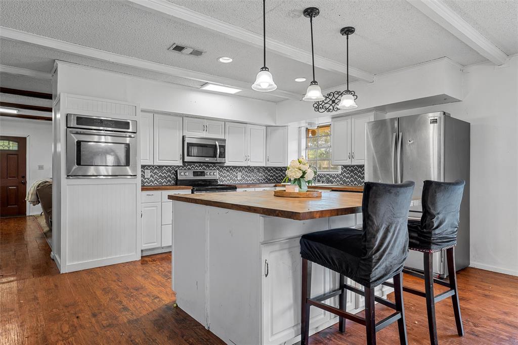 626 Sommerfeld Drive Waco, TX 76705 - Photo 9 of 26 a kitchen with kitchen island a dining table chairs stainless steel appliances and cabinets