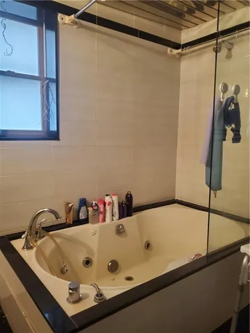 a bathroom with a tub and a shower