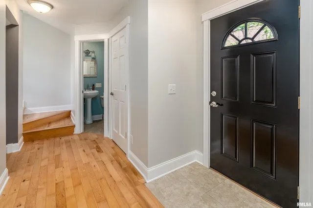 a view of a hallway with wooden floor and staircase