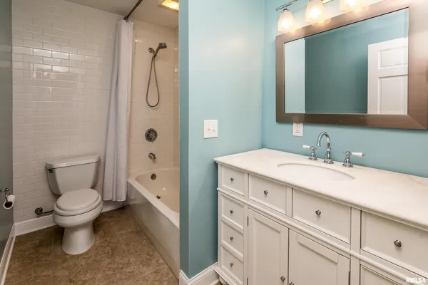 a spacious bathroom with a granite countertop toilet sink and a mirror