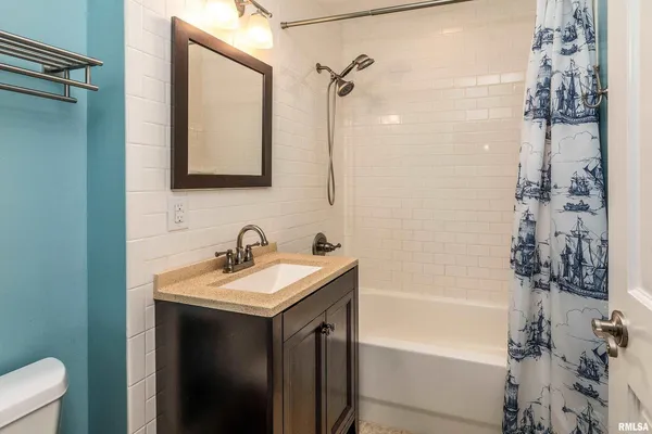 a bathroom with a tub sink and mirror