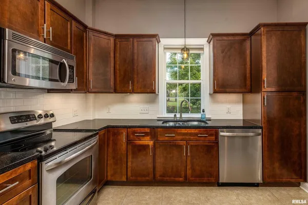 a kitchen with a sink stove and microwave