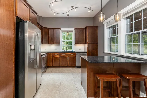 a kitchen with stainless steel appliances granite countertop a refrigerator and a sink