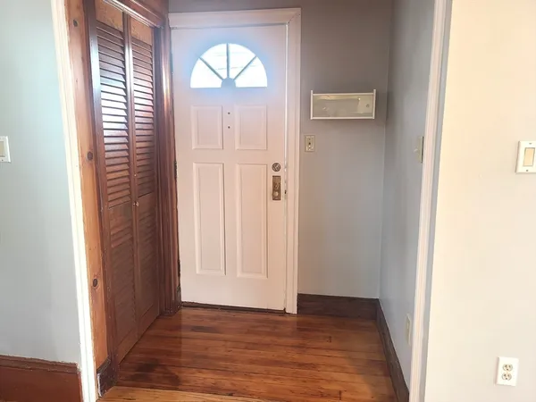 an empty room with wooden floor & windows