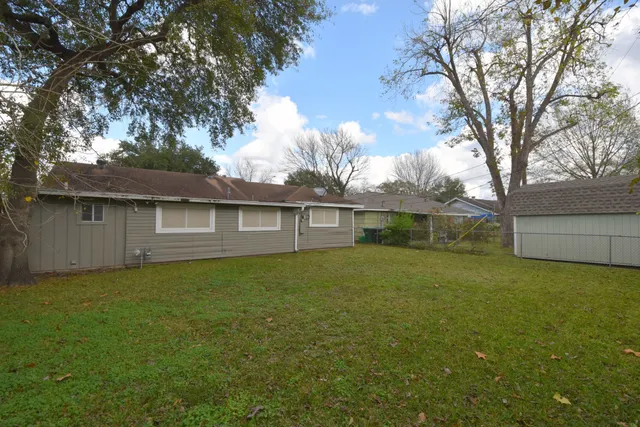 a view of a yard in front of a house with large tree