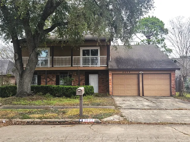 a front view of a house with a yard garage and tree