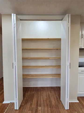 a view of walk in closet with empty racks