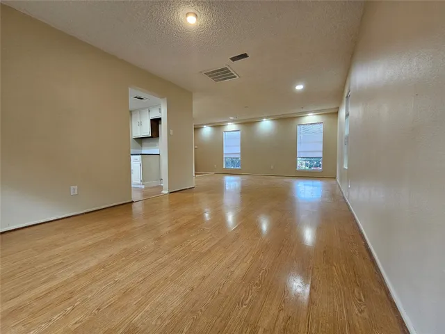 a view of an empty room with wooden floor