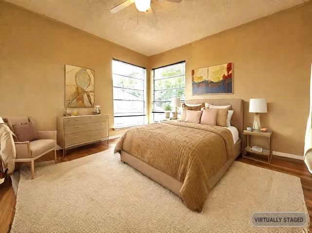 a spacious bedroom with a bed and painting on the wall