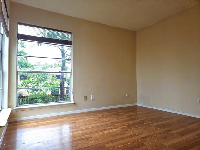 a view of a room with wooden floor and a window