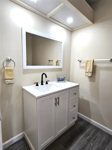 a view of bathroom with sink mirror and window