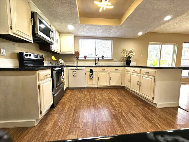 a kitchen with stainless steel appliances granite countertop wooden floors and sink