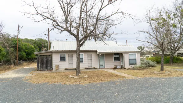 a front view of house with yard and trees around