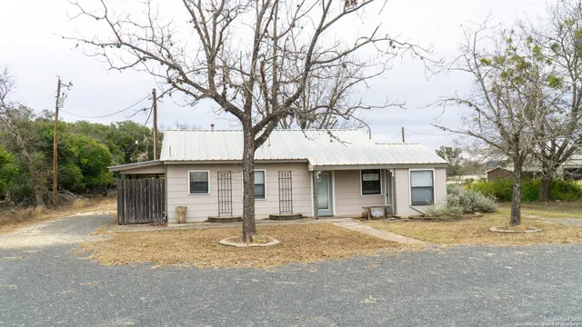 a front view of house with yard and trees around