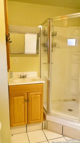 a bathroom with a granite countertop shower and a sink