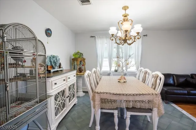a dining room with furniture a chandelier and window