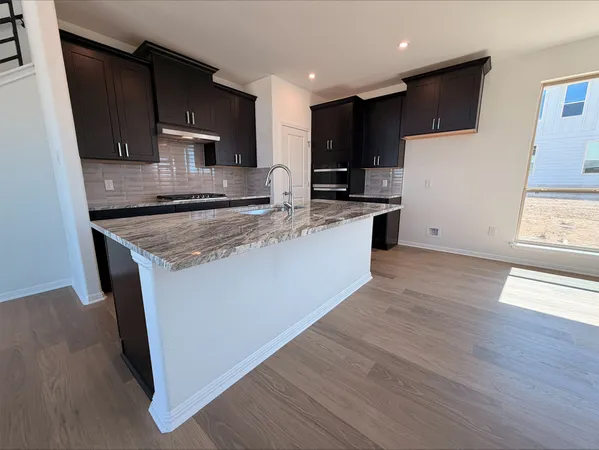 a kitchen with stainless steel appliances granite countertop a stove a sink and a microwave