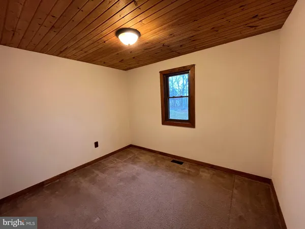 an empty room with a ceiling fan and window