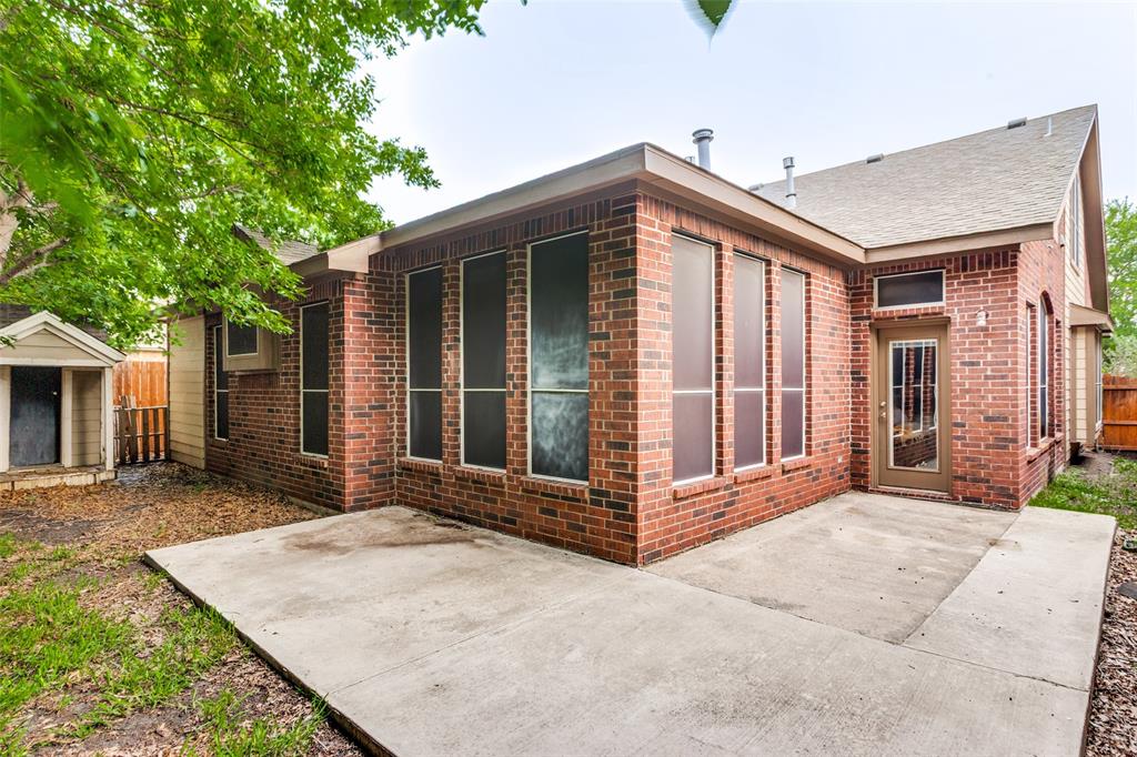 9117 Ripley Street Fort Worth, TX 76244 - Photo 33 of 35 Expansive brick exterior with a concrete patio, multiple floor-to-ceiling windows, and a glass-paneled door