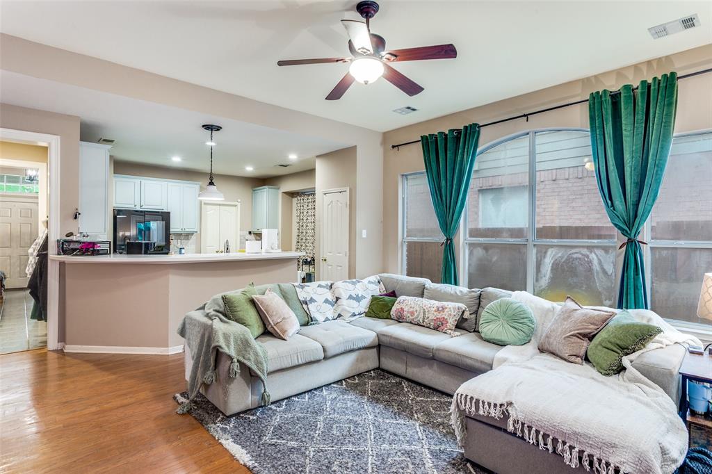 9117 Ripley Street Fort Worth, TX 76244 - Photo 6 of 35 Open-concept living area featuring wood-finish flooring, an arched window, and a ceiling fan with integrated lighting