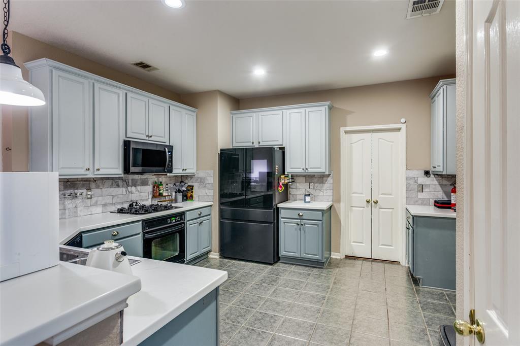 9117 Ripley Street Fort Worth, TX 76244 - Photo 8 of 35 Kitchen featuring light blue cabinetry, white countertops, tile flooring, a built-in microwave, and a gas range