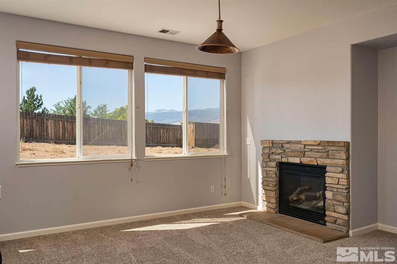 3443 Weaver Place Reno, NV 89512 - Photo 2 of 23 an empty room with windows fire place and a fireplace